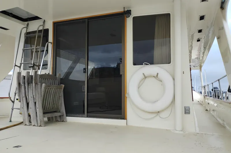 Slide: The Image of 1977 Custom International Offshore 65 yacht deck with chairs, ladder, and life preserver. - 18