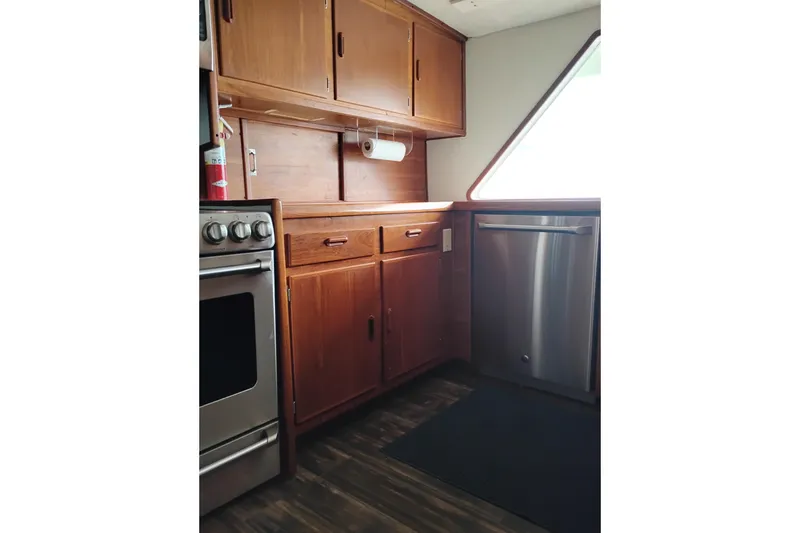 Slide: The Image of 1977 Custom International Offshore 65 yacht kitchen with wooden cabinets and stainless steel appliances. - 33