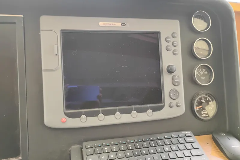 Slide: The Image of Control panel of a 1977 Custom International Offshore 65 boat with gauges and navigation screen. - 47