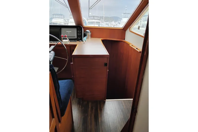 Slide: The Image of Interior of 1977 Custom International Offshore 65 yacht with wooden finishes and navigation equipment. - 48