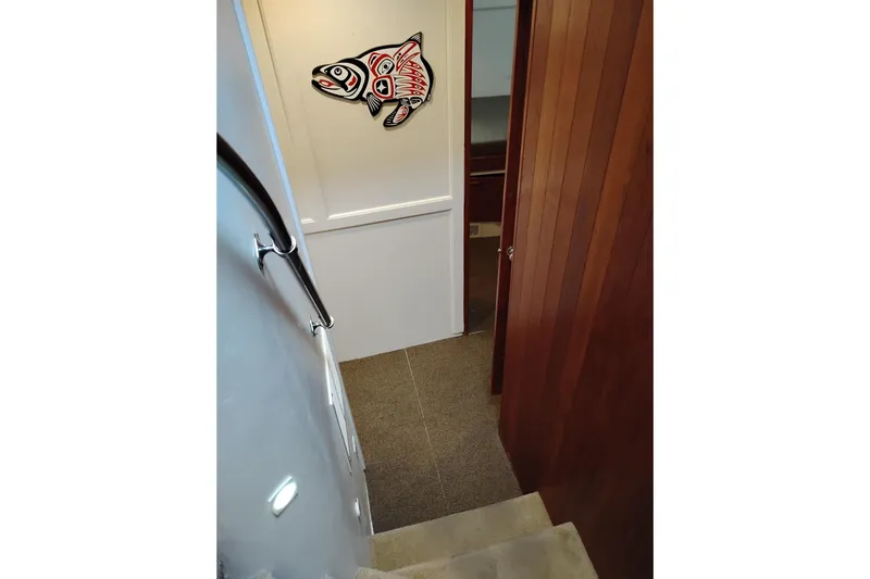 Slide: The Image of Staircase inside 1977 Custom International Offshore 65 yacht with fish wall art. - 49