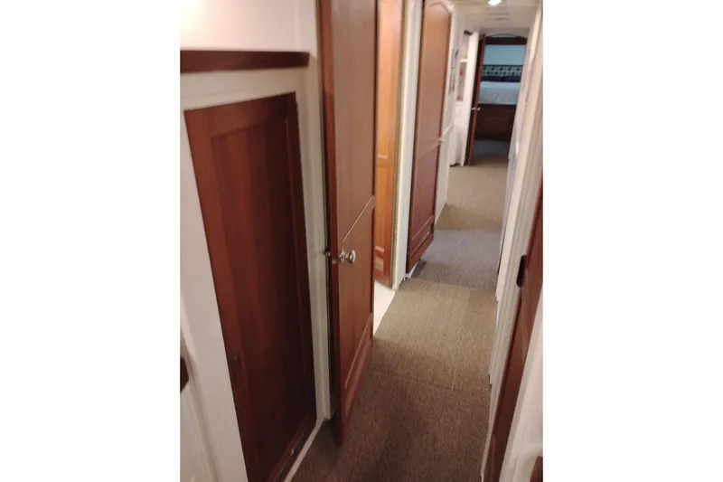 Slide: The Image of Interior hallway of 1977 Custom International Offshore 65 yacht with wooden doors and carpeted floor. - 53