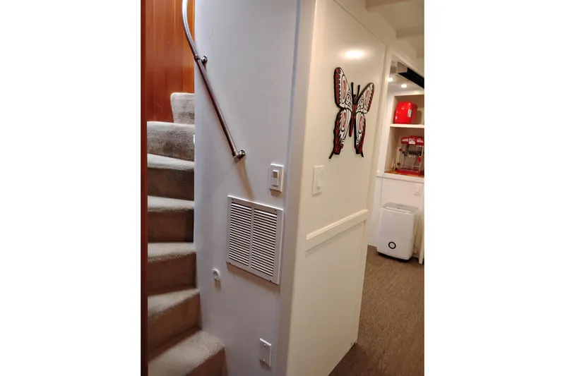 Slide: The Image of Interior of 1977 Custom International Offshore 65 with stairs and butterfly wall art. - 54