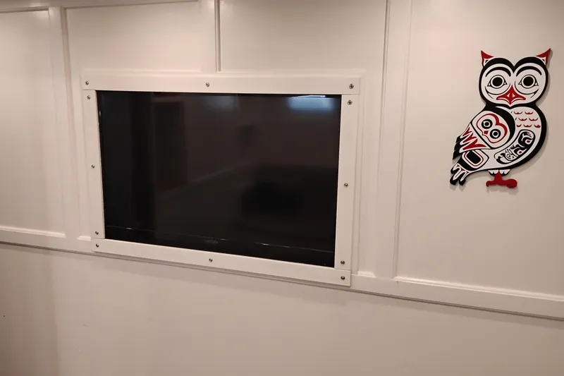 Slide: The Image of Wall-mounted TV with decorative owl art on a 1977 Custom International Offshore 65 yacht. - 57