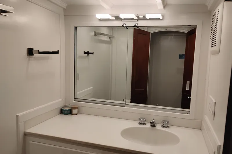 Slide: The Image of Bathroom interior of 1977 Custom International Offshore 65 yacht, featuring a mirror and sink. - 64