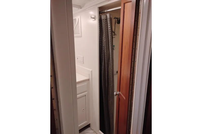 Slide: The Image of Narrow bathroom with shower and wooden door on a 1977 Custom International Offshore 65 yacht. - 66