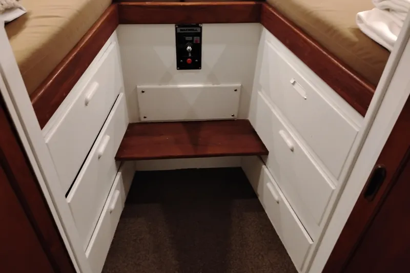 Slide: The Image of Interior of 1977 Custom International Offshore 65 with wooden drawers and seating area. - 68