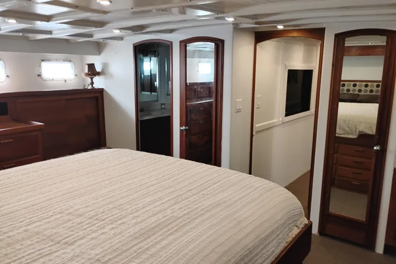 Slide: The Image of Luxurious bedroom interior of 1977 Custom International Offshore 65 yacht with elegant wood finishes. - 76