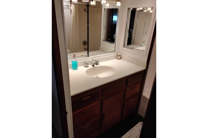 Slide: The Image of Bathroom vanity with mirror and sink on a 1977 Custom International Offshore 65 yacht. - 78