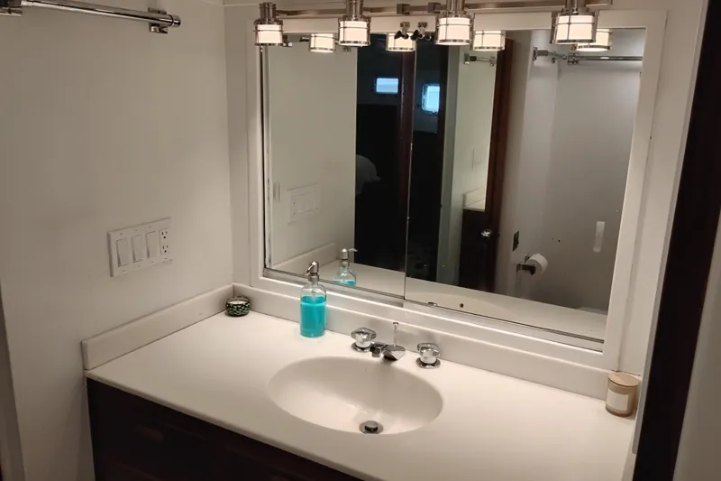 Slide: The Image of Bathroom vanity with mirror and lighting on a 1977 Custom International Offshore 65 yacht. - 79