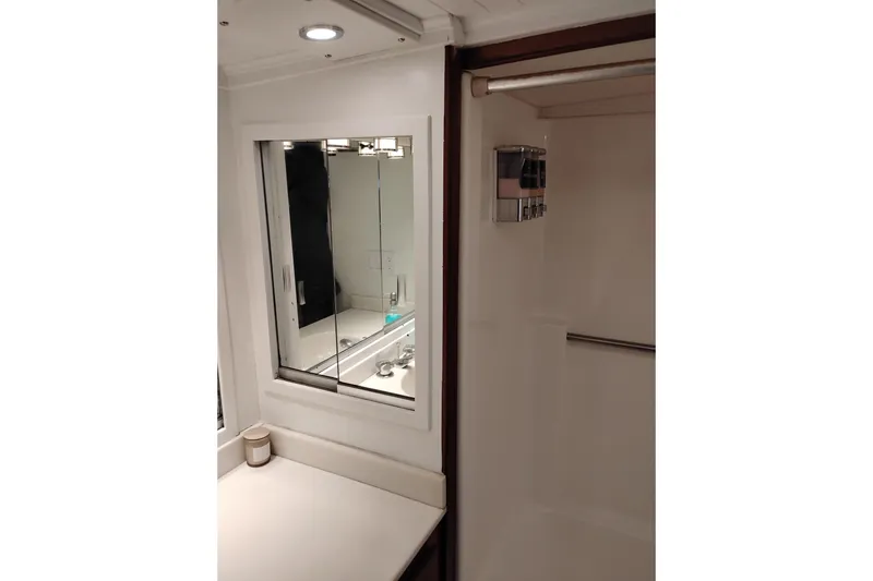 Slide: The Image of Bathroom interior of 1977 Custom International Offshore 65 yacht, featuring mirror and shower area. - 81