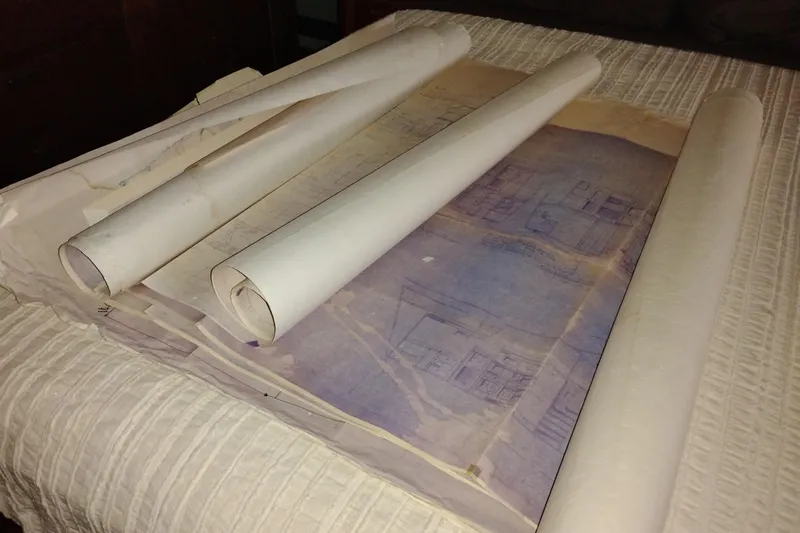 Slide: The Image of Rolled blueprints on a table, possibly for a 1977 Custom International Offshore 65. - 85