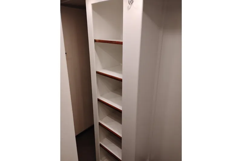 Slide: The Image of Narrow white shelving unit with wooden accents on a 1977 Custom International Offshore 65. - 88