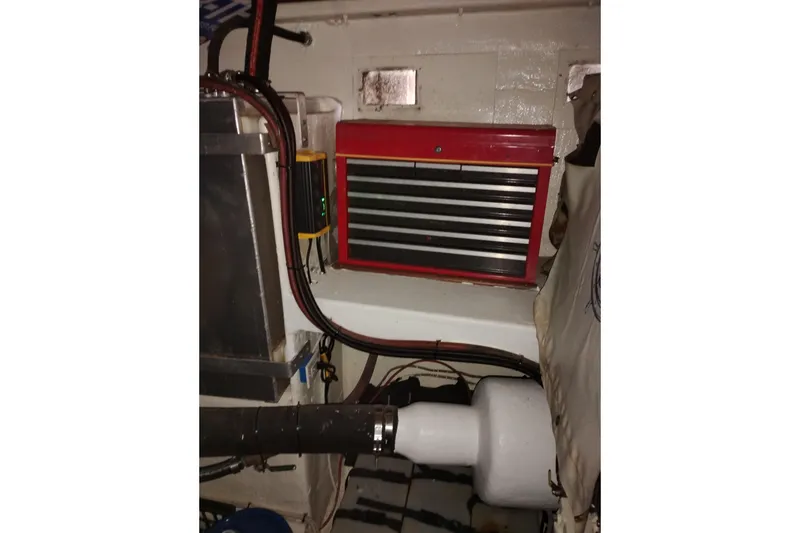 Slide: The Image of Engine room of 1977 Custom International Offshore 65 with red tool chest and wiring. - 98