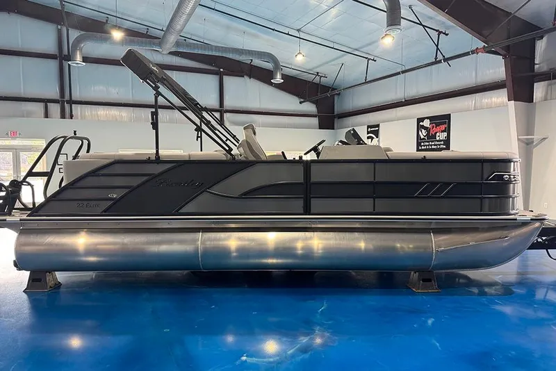 The Image of 2026 Bentley Pontoons Elite 223 Admiral in showroom, sleek design, blue floor, industrial ceiling. - 1
