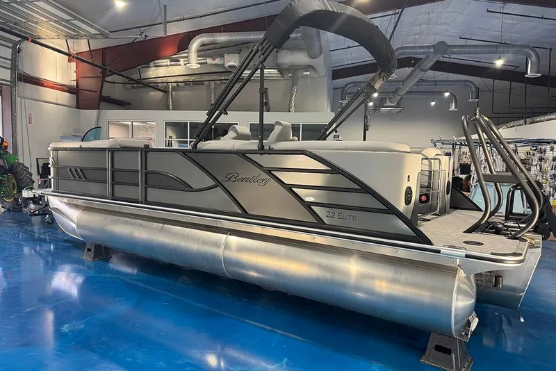 Slide: The Image of 2026 Bentley Pontoons Elite 223 Admiral in showroom, sleek design, luxury pontoon boat. - 6