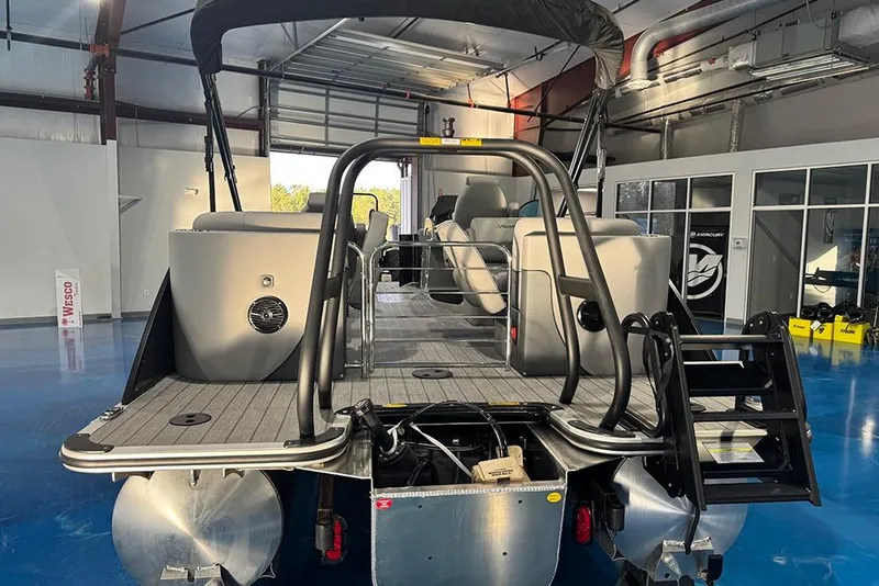 Slide: The Image of 2026 Bentley Pontoons Elite 223 Admiral in a showroom, rear view with seating and ladder. - 7