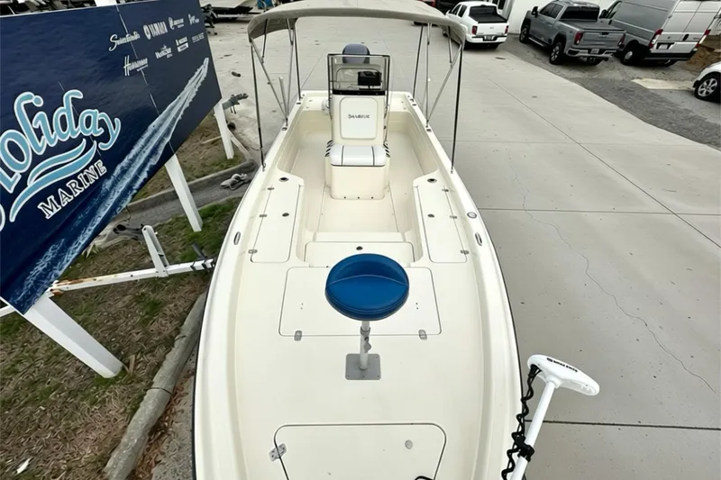 Slide: The Image of 2006 ShearWater 2400Z boat with canopy, parked at marina, featuring a blue seat. - 12