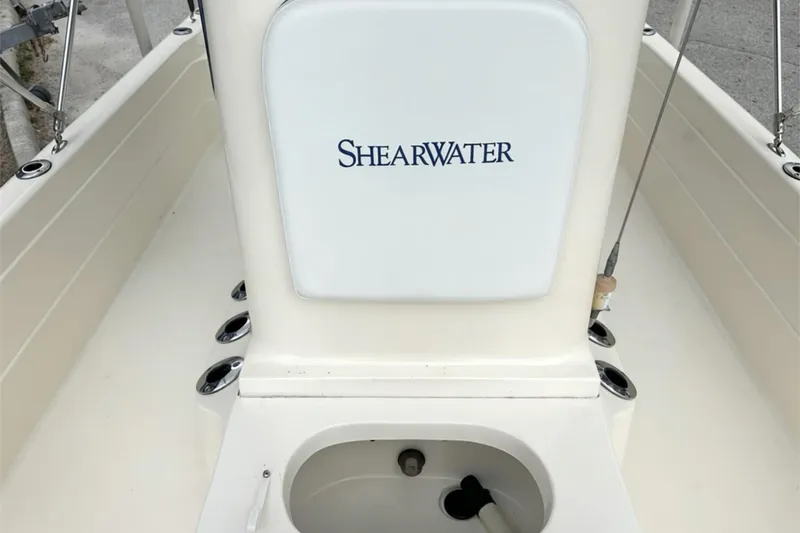 Slide: The Image of 2006 ShearWater 2400Z boat interior with storage compartment and rod holders. - 14