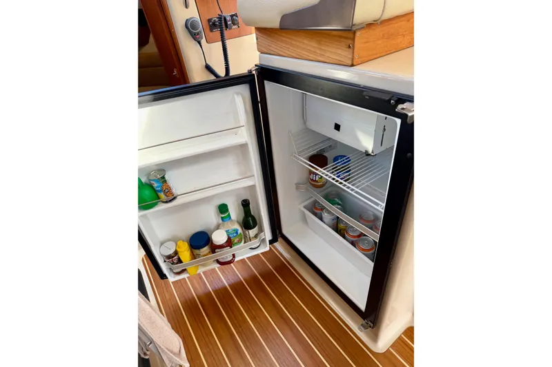 Slide: The Image of Open fridge in 2012 Ranger Tugs R-29 boat, stocked with condiments and beverages. - 13