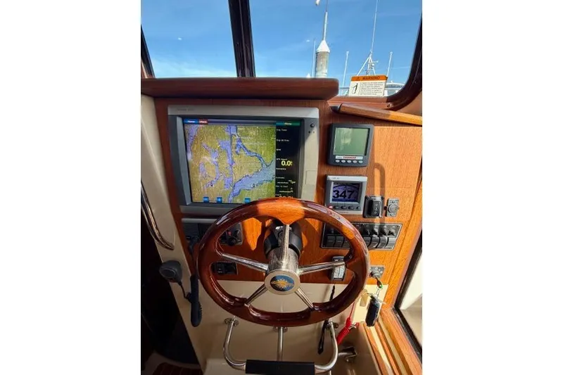 Slide: The Image of 2012 Ranger Tugs R-29 helm with navigation display and wooden steering wheel. - 16