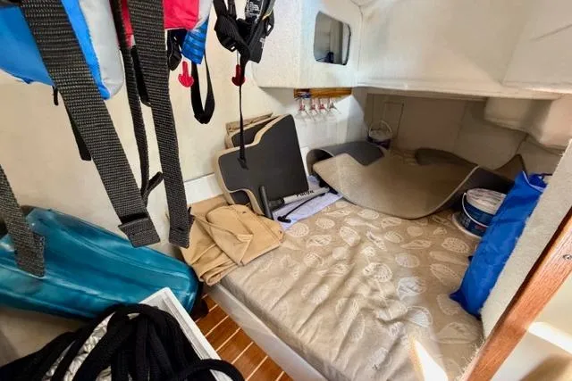 Slide: The Image of 2012 Ranger Tugs R-29 cabin interior with bed, storage, and nautical gear. - 23