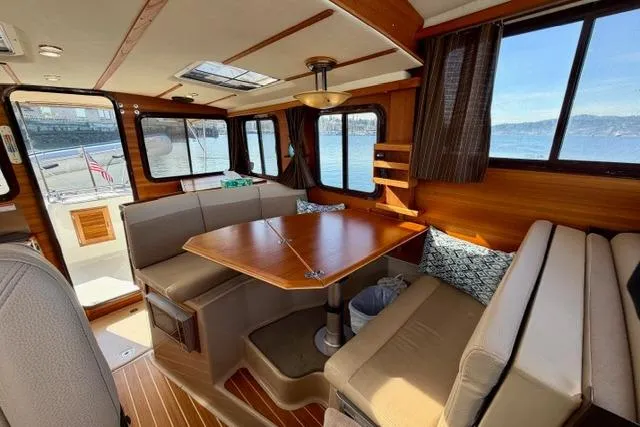Slide: The Image of Interior of 2012 Ranger Tugs R-29 boat with wooden dining area and large windows. - 28