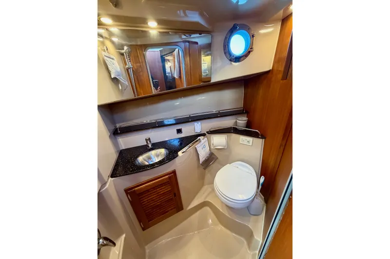 Slide: The Image of 2012 Ranger Tugs R-29 boat bathroom with sink, toilet, and porthole window. - 35