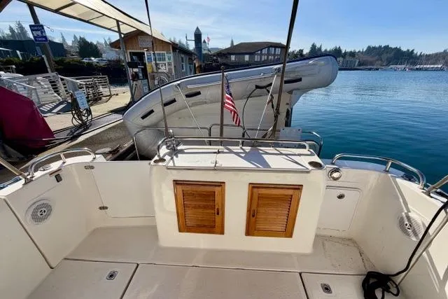 Slide: The Image of 2012 Ranger Tugs R-29 boat deck with wooden storage, docked at a marina. - 37