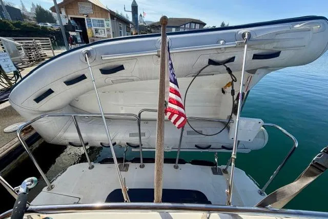 Slide: The Image of 2012 Ranger Tugs R-29 with dinghy and American flag at marina dock. - 38