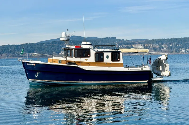 Slide: The Image of 2012 Ranger Tugs R-29 boat on calm water with scenic background. - 4
