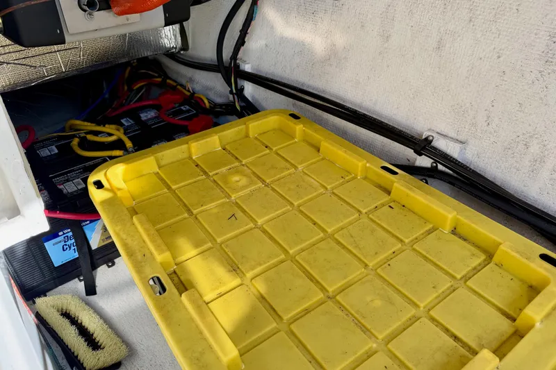 Slide: The Image of Yellow storage compartment in 2012 Ranger Tugs R-29 boat, with visible wiring and battery. - 45