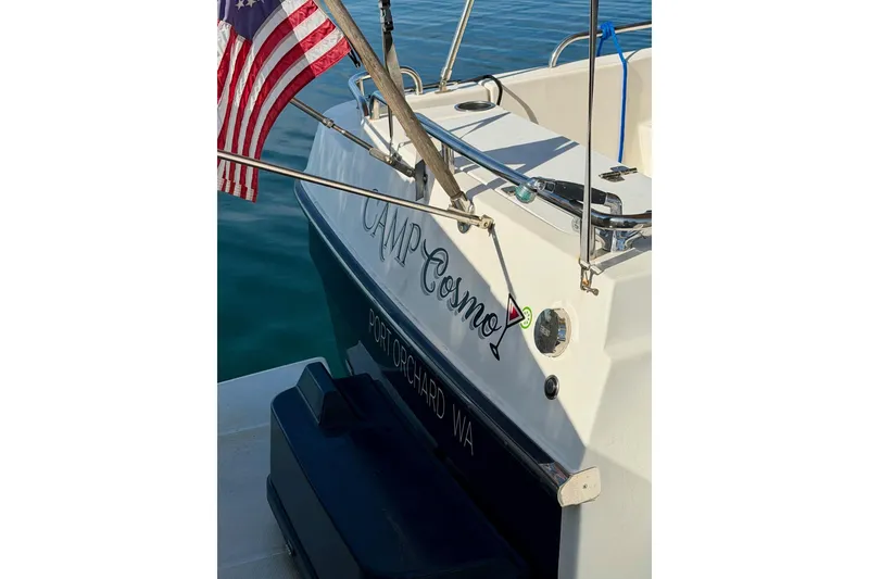 Slide: The Image of 2012 Ranger Tugs R-29 boat with American flag, named "Camp Cosmo," docked in Port Orchard, WA. - 53