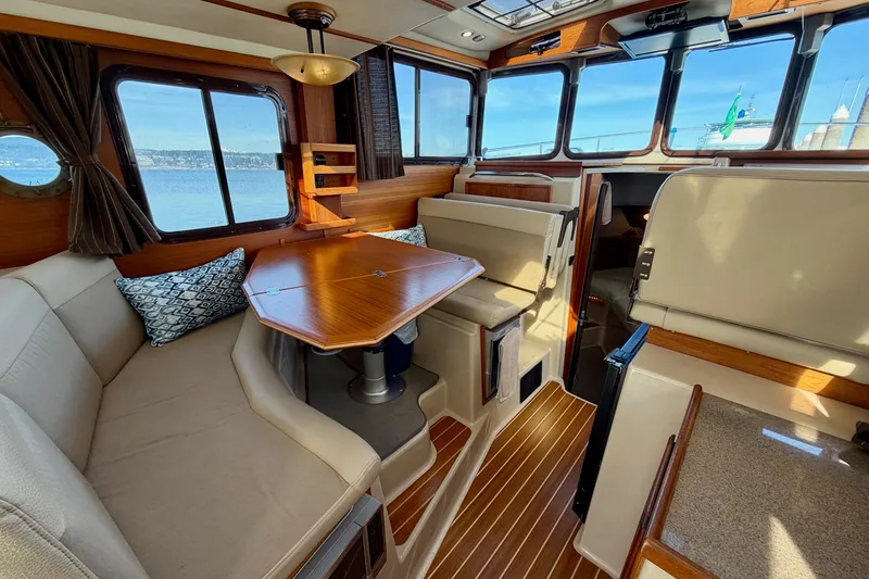 Slide: The Image of Interior of 2012 Ranger Tugs R-29 boat with cozy seating and wooden table. - 9