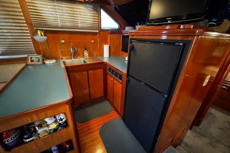 Slide: The Image of 1998 Mikelson 43 Sportfisher yacht kitchen with wood cabinetry and modern appliances. - 12