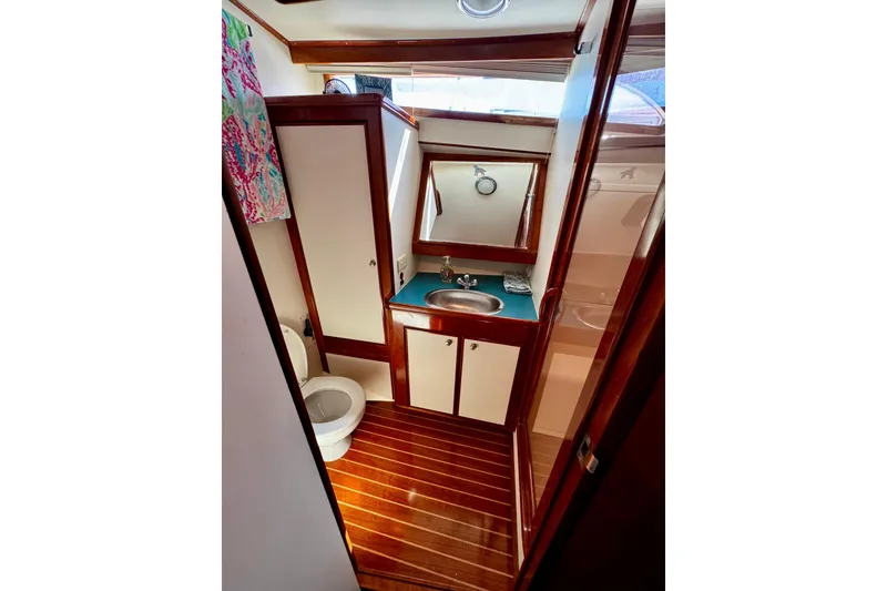 Slide: The Image of Bathroom interior of 1998 Mikelson 43 Sportfisher with wood accents and compact design. - 15
