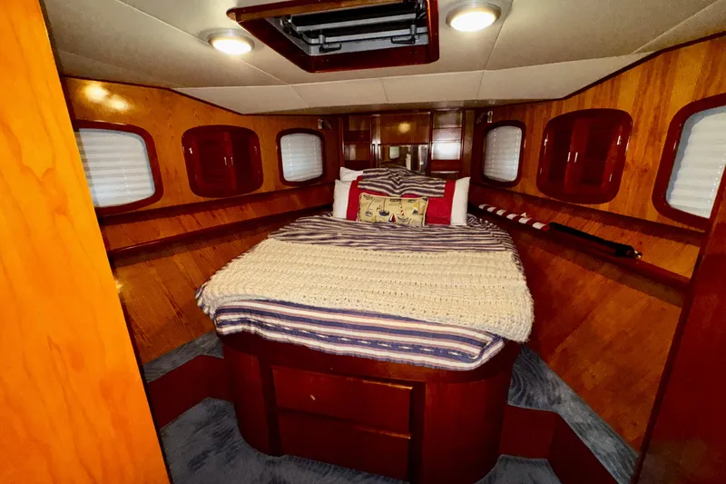 Slide: The Image of Cozy cabin interior of 1998 Mikelson 43 Sportfisher with wood paneling and comfortable bedding. - 18