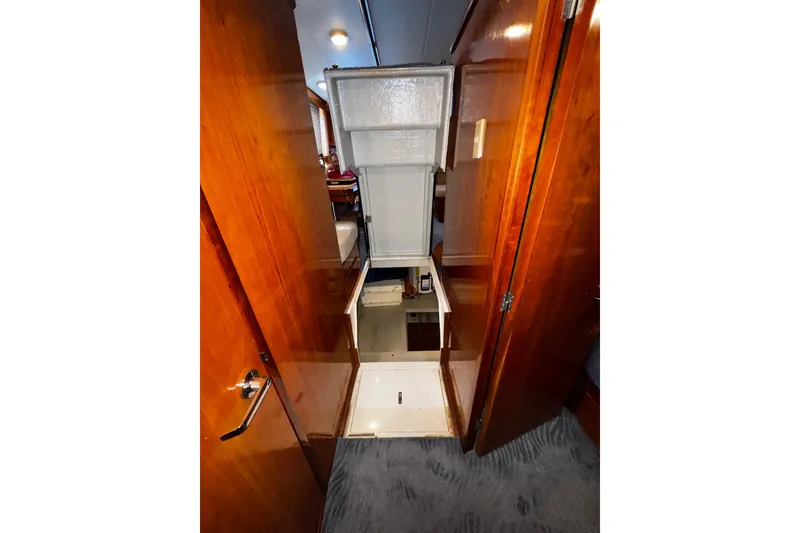 Slide: The Image of Interior view of 1998 Mikelson 43 Sportfisher yacht with wooden cabinetry and carpeted flooring. - 19