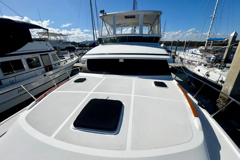 Slide: The Image of 1998 Mikelson 43 Sportfisher yacht docked at marina under clear blue sky. - 2