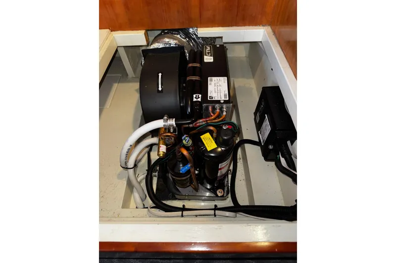 Slide: The Image of Engine compartment of 1998 Mikelson 43 Sportfisher, showcasing mechanical components and wiring. - 24