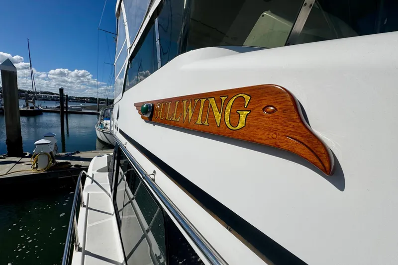 Slide: The Image of 1998 Mikelson 43 Sportfisher docked, featuring "Gullwing" wooden nameplate. - 5