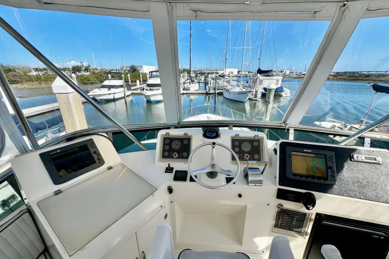Slide: The Image of Cockpit view of 1998 Mikelson 43 Sportfisher yacht at marina, featuring navigation equipment. - 9