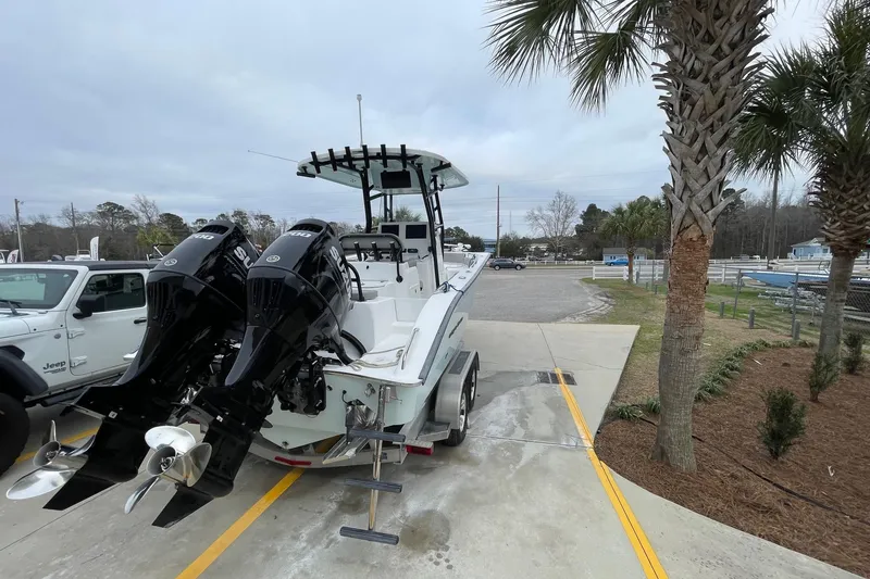 Slide: The Image of 2023 Cape Horn 24 XS boat with dual Suzuki outboard motors, parked near palm trees. - 4