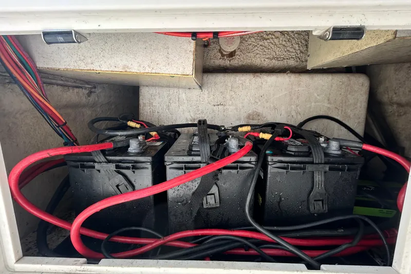Slide: The Image of 2018 NauticStar 28 XS boat battery compartment with red and black cables. - 100