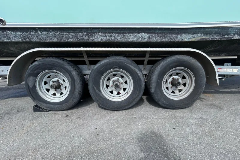Slide: The Image of Triple-axle trailer for 2018 NauticStar 28 XS boat on pavement. - 101