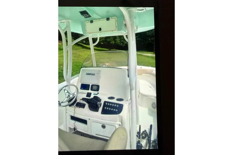 Slide: The Image of 2018 NauticStar 28 XS boat with spacious deck and seating, parked in a marina. - 11