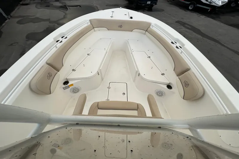 Slide: The Image of 2018 NauticStar 28 XS boat interior with helm and seating, docked outdoors. - 13