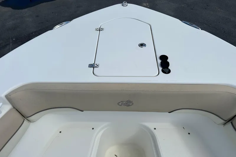 Slide: The Image of 2018 NauticStar 28 XS boat bow with storage compartment and cushioned seating. - 26