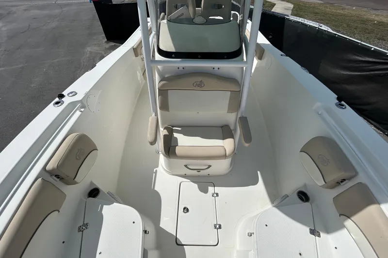Slide: The Image of 2018 NauticStar 28 XS boat interior with beige seating and storage compartments. - 32