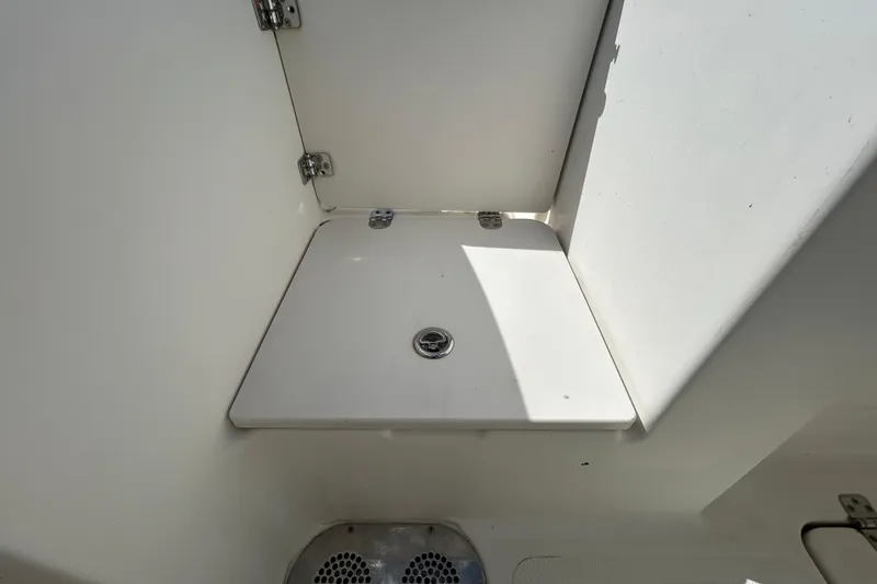 Slide: The Image of 2018 NauticStar 28 XS boat storage compartment with hinged lid and latch. - 40